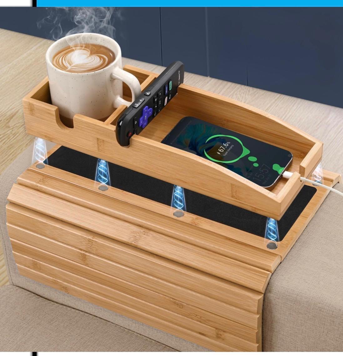 Bamboo sofa armrest tray with cup holder, remote slot and wireless charging pad resting on a couch arm